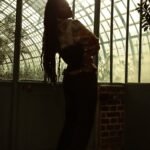 A woman standing in front of a glass wall