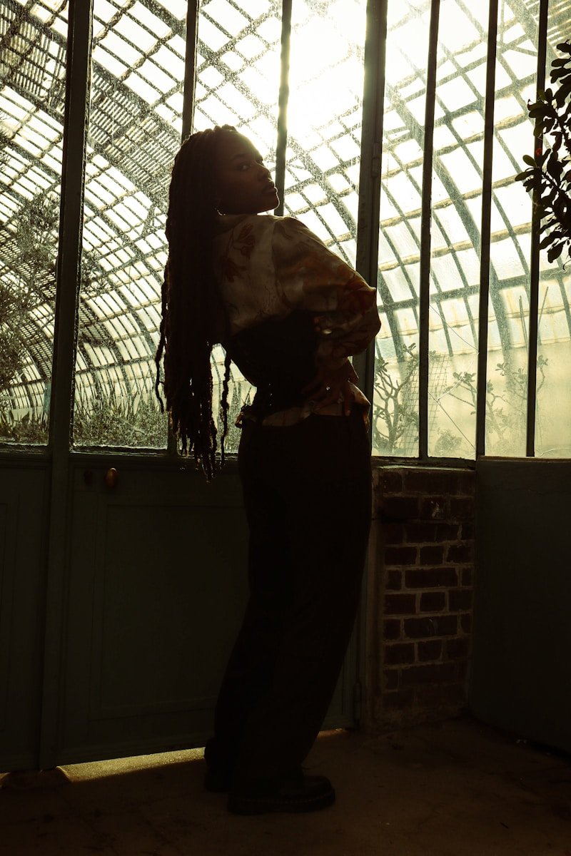 A woman standing in front of a glass wall