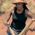 A woman holding a stick and a wooden stick